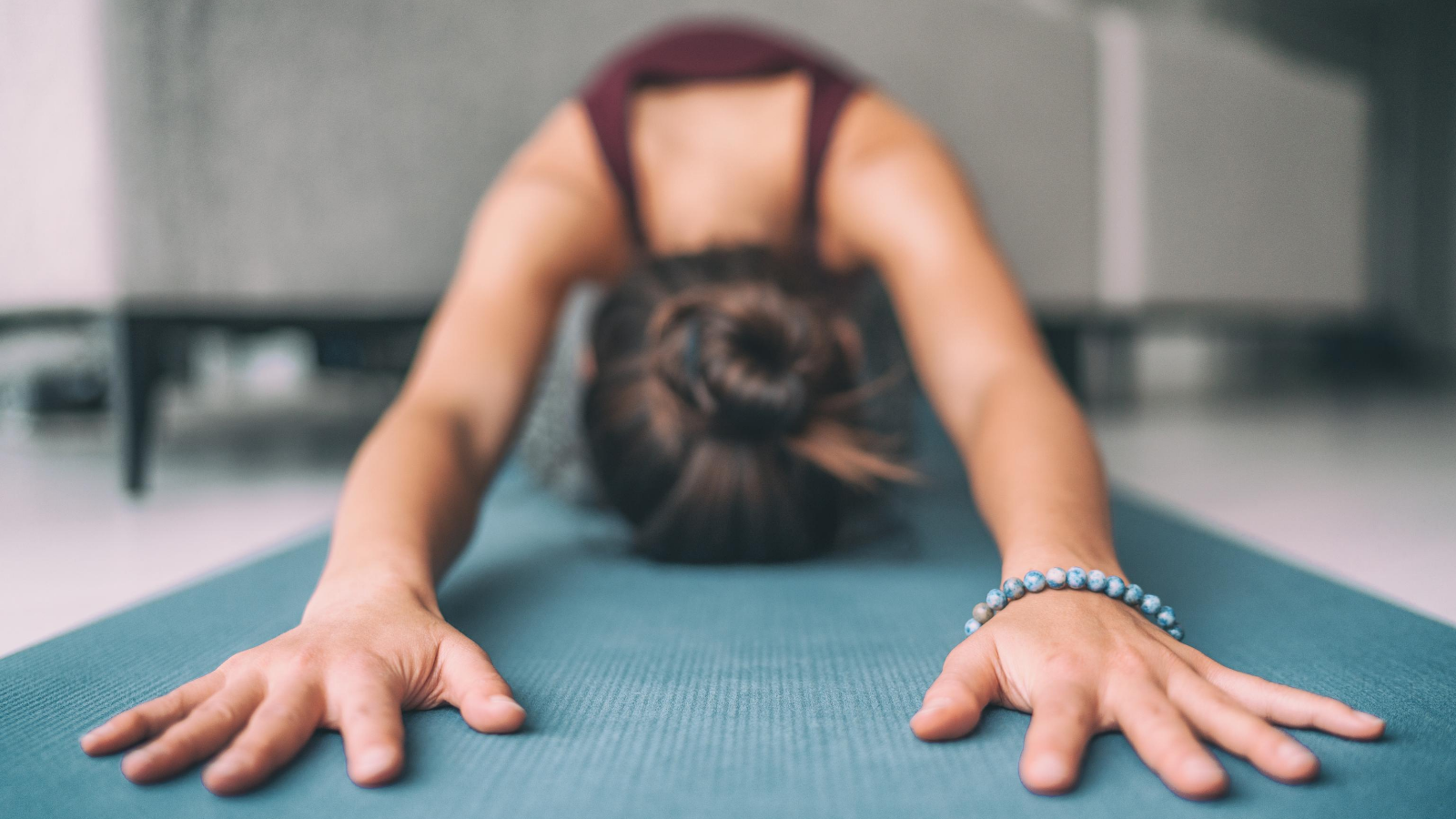 beginner yoga student practicing child's pose (sanskrit name: balasana) in yoga class for pelvic for health