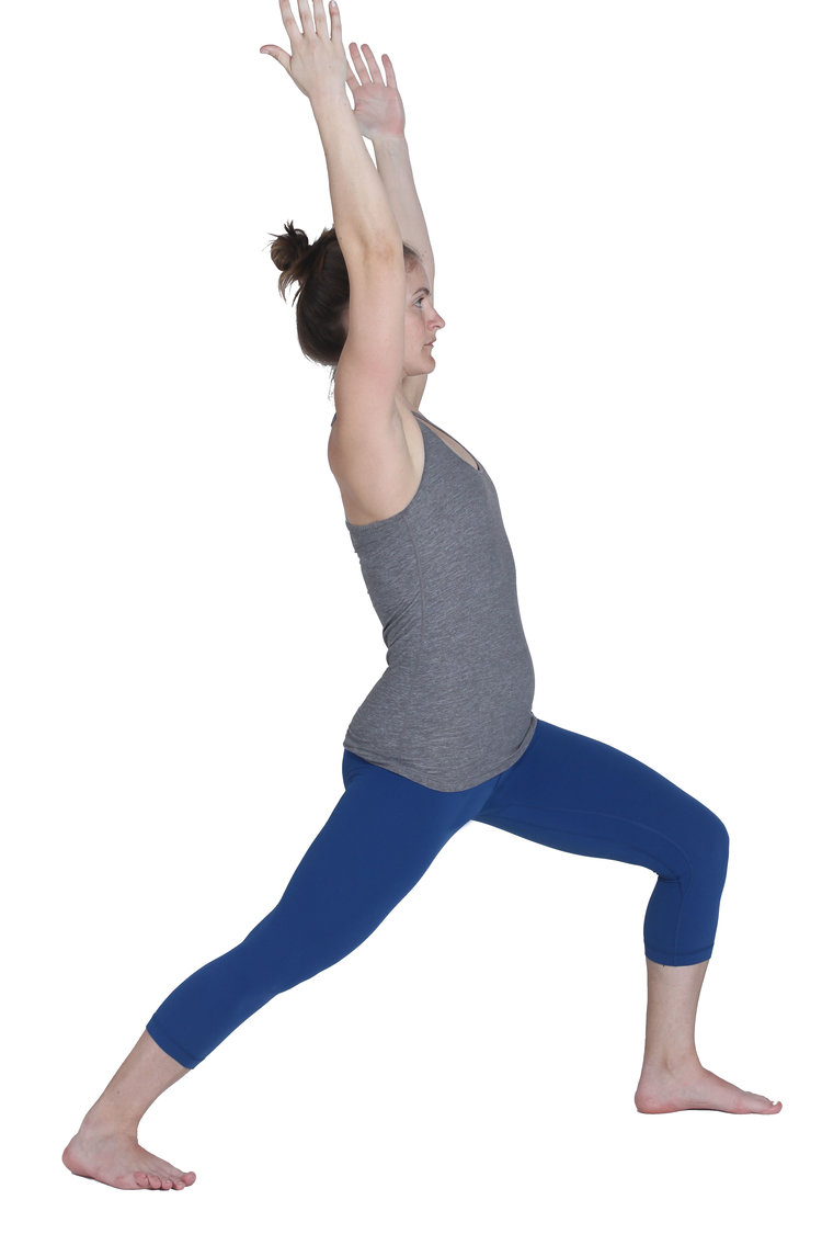 A woman in Warrior 1 yoga pose (Virabhadrasana I)