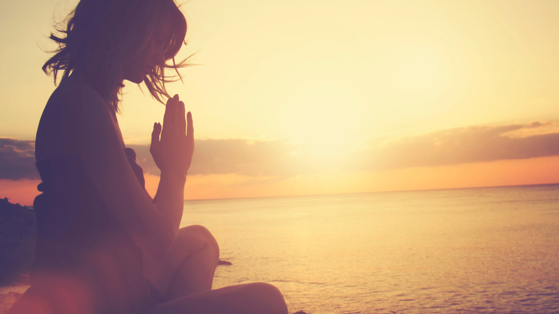 Woman meditating on a beautiful sunrise. 