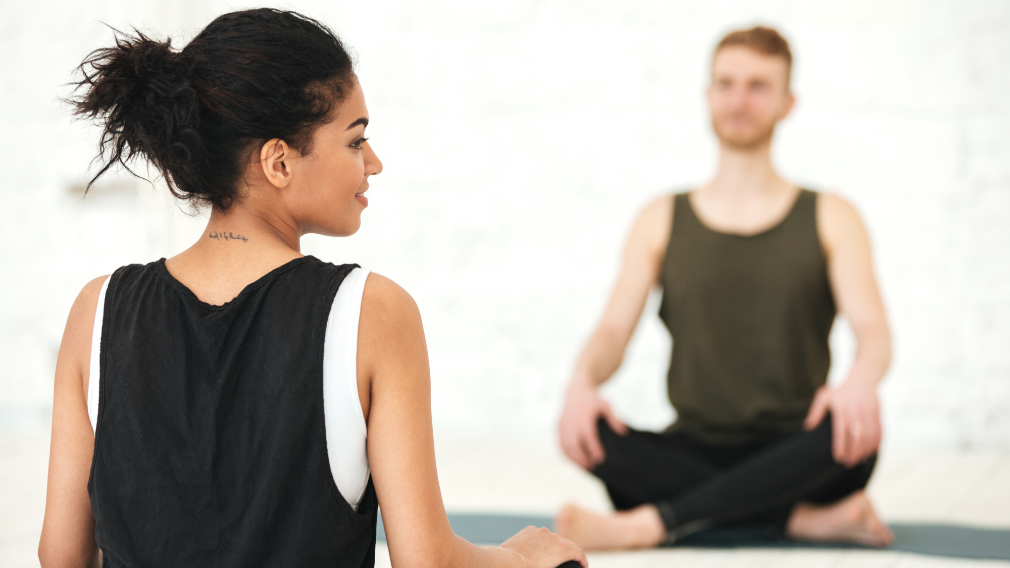 Female yoga teacher guiding her yoga student in mindful practice.