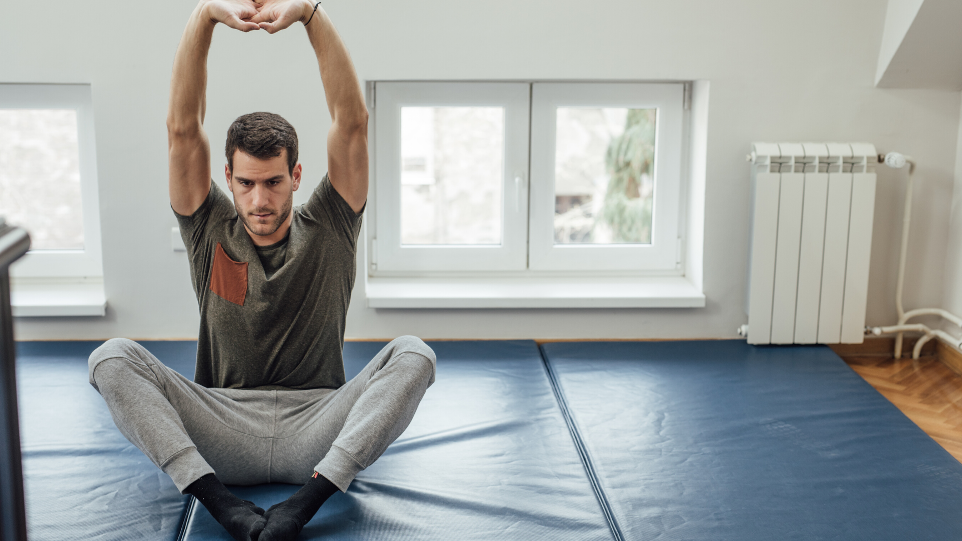 Male yoga student practicing yoga stretches at home