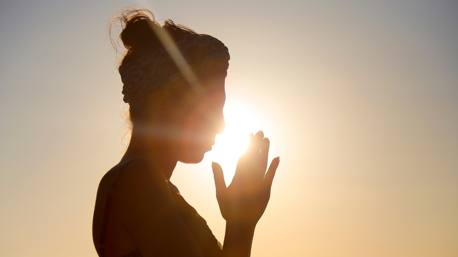 This is very serene scene in the beach. Woman reflecting at sunset.