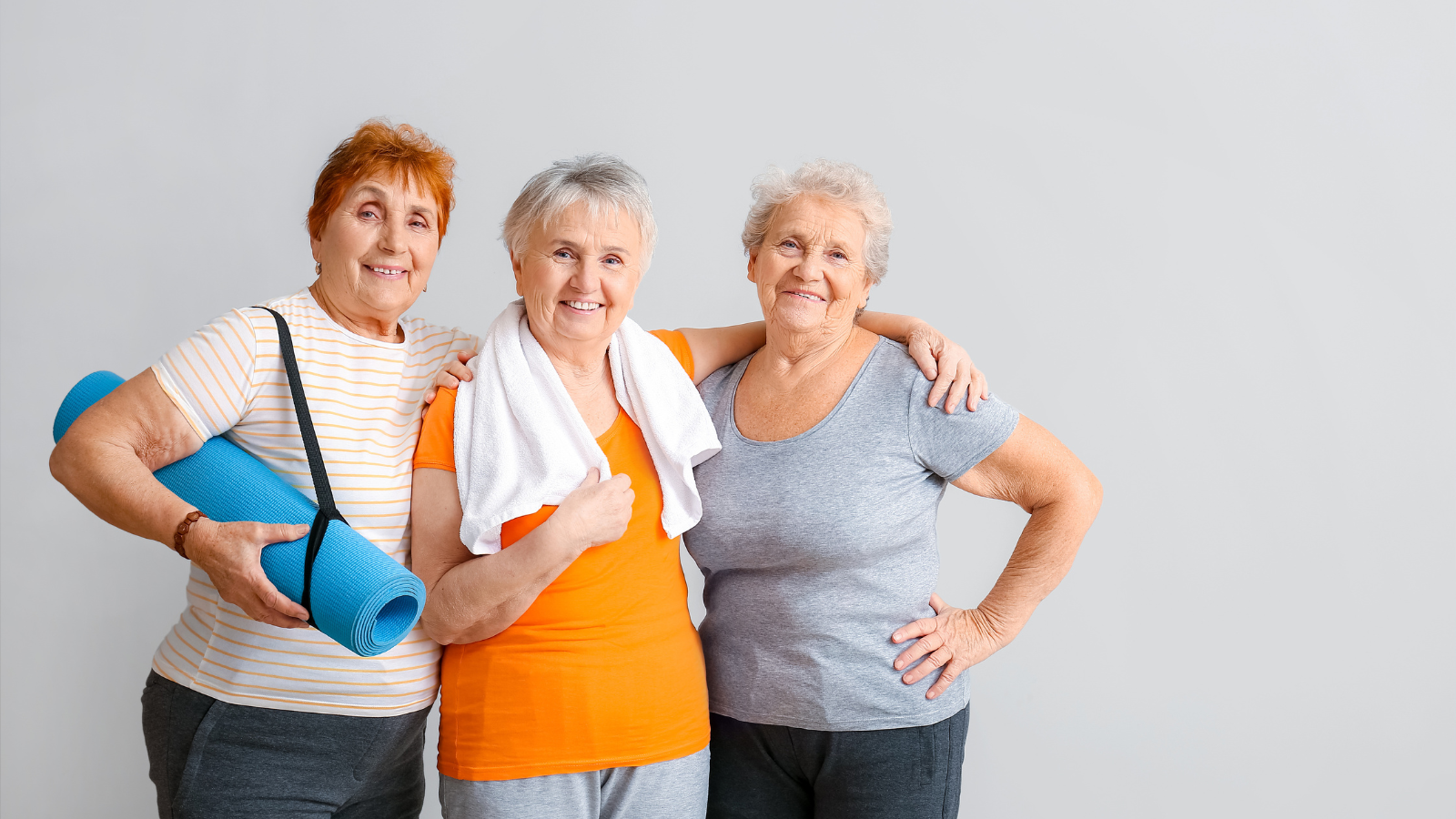 Happy mature women with yoga mats.