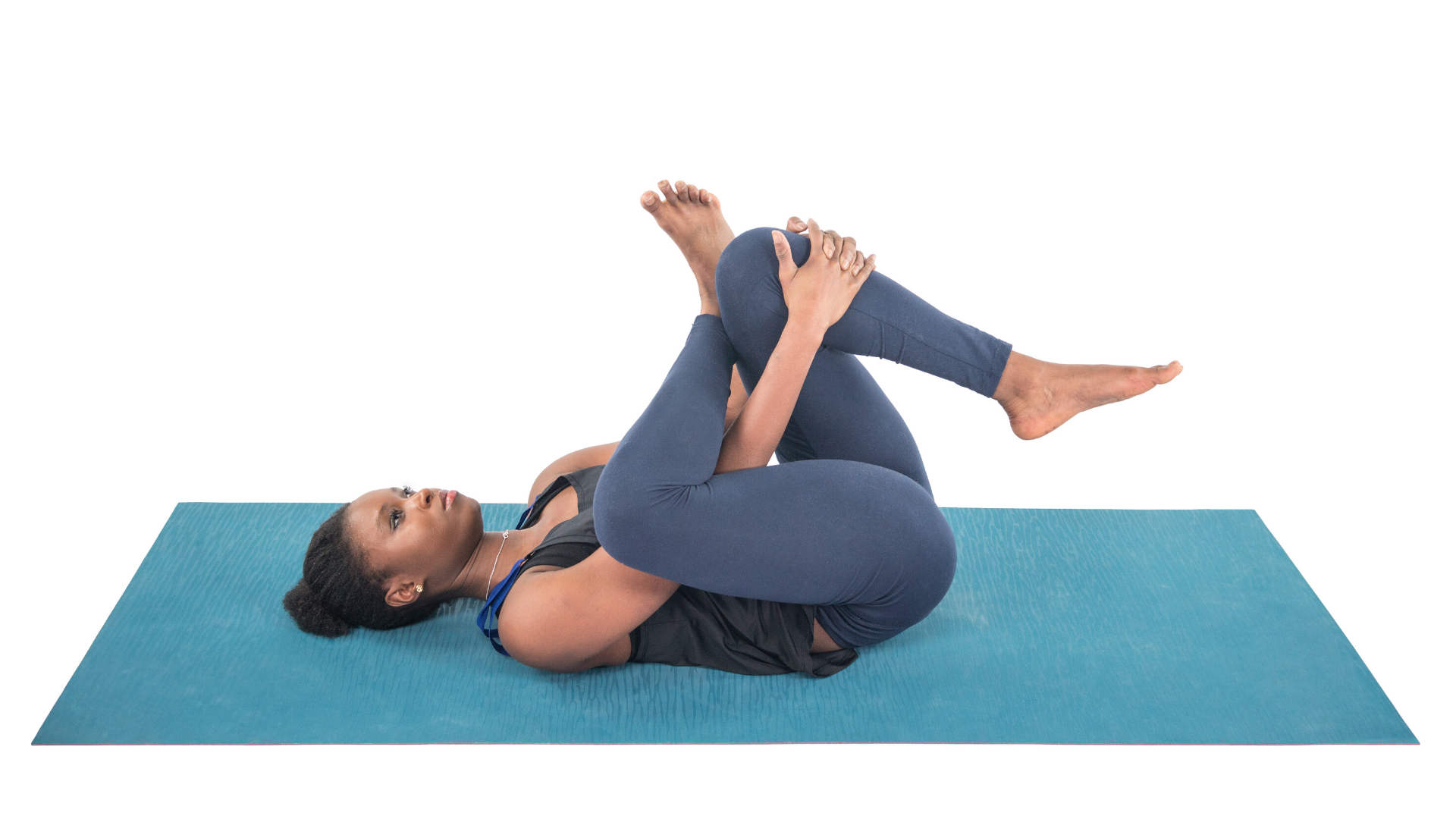 Woman practicing yoga Reclining Half Pigeon pose (Ardha Kapotasana).