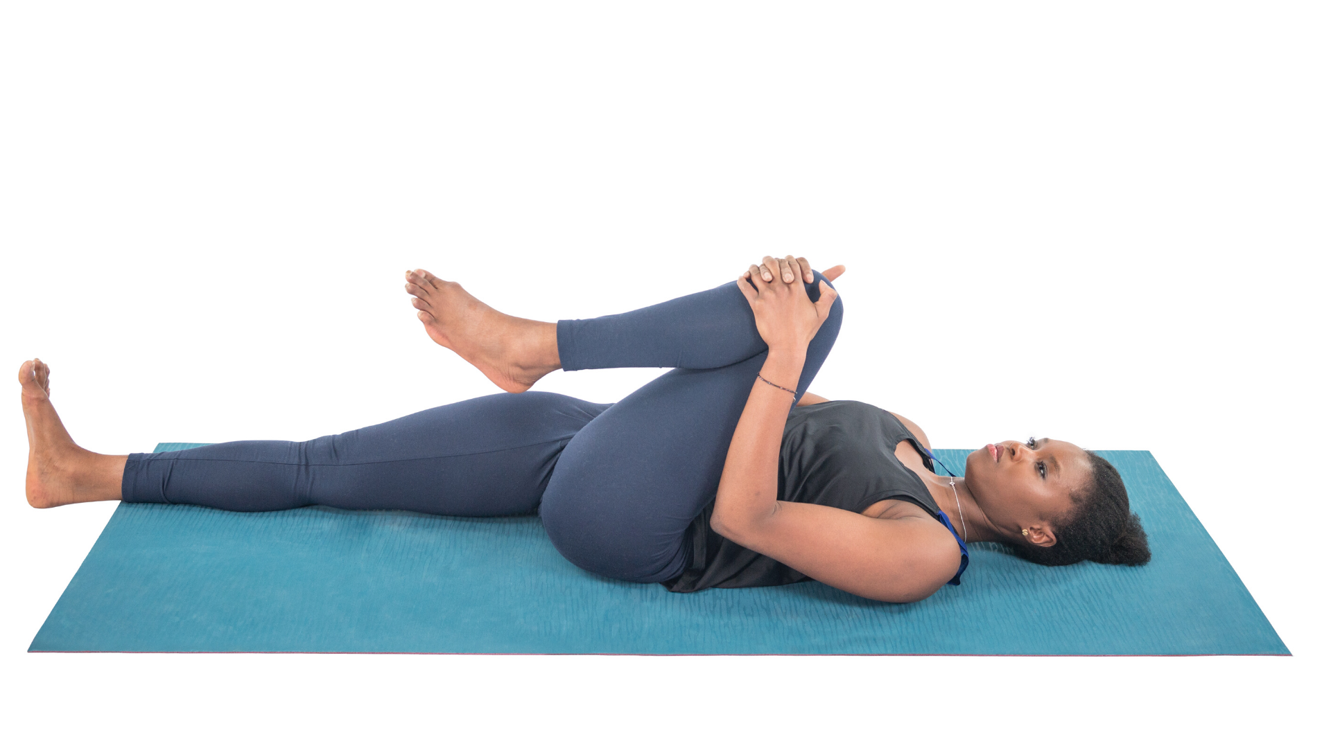 Woman practicing ardha apanasana knee to chest yoga pose.