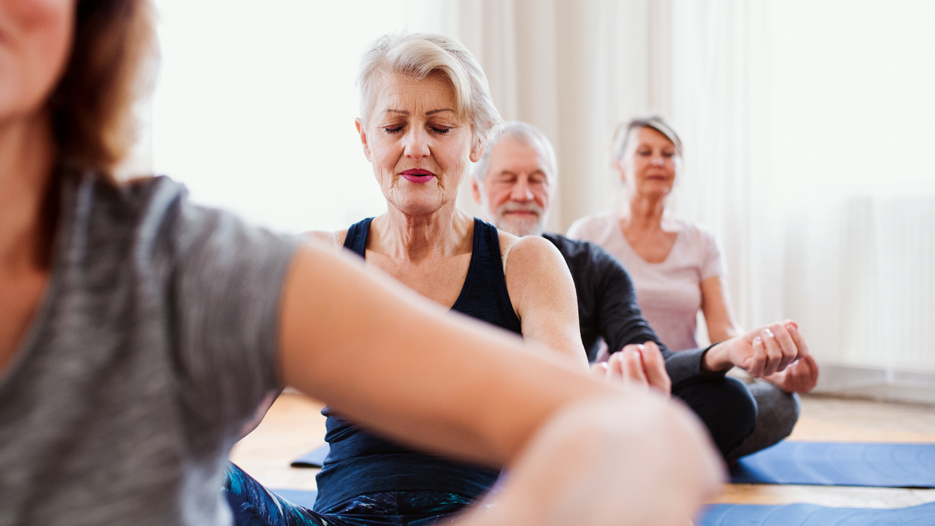 Older woman practicing meditation in class.