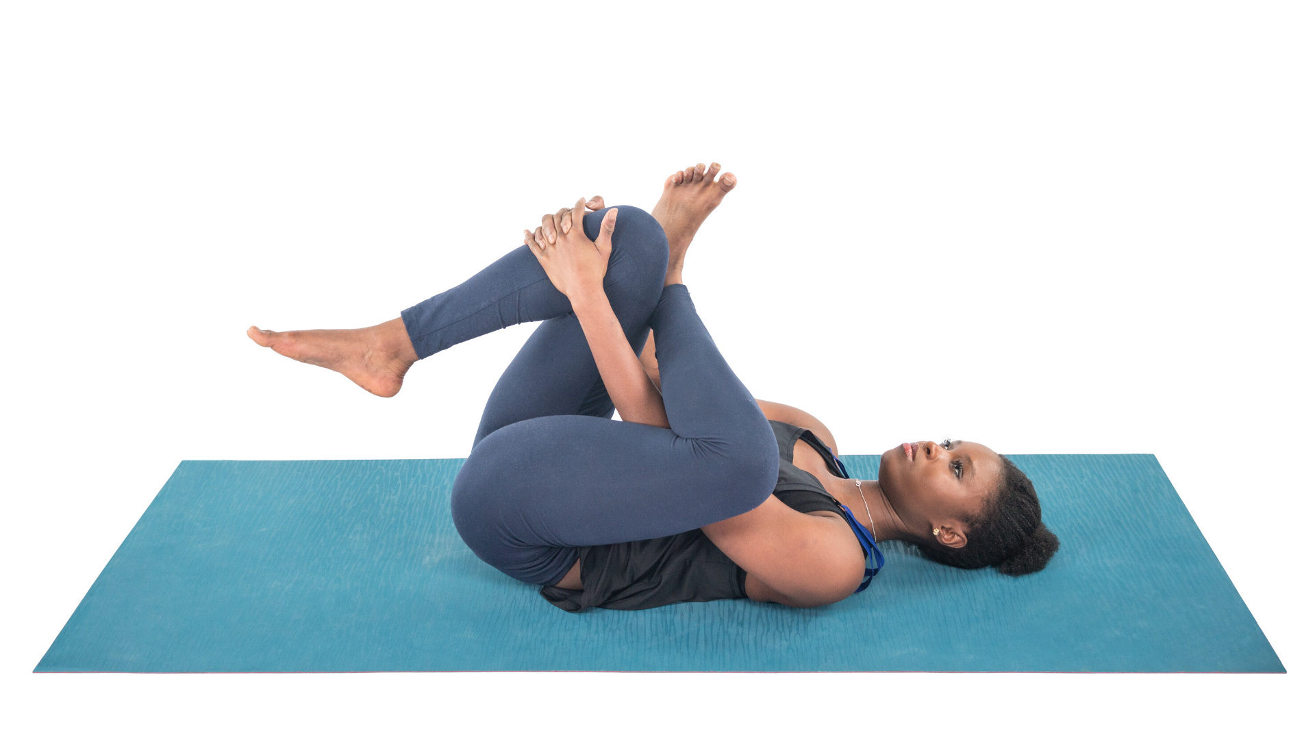 Woman practicing reclining pigeon yoga pose.