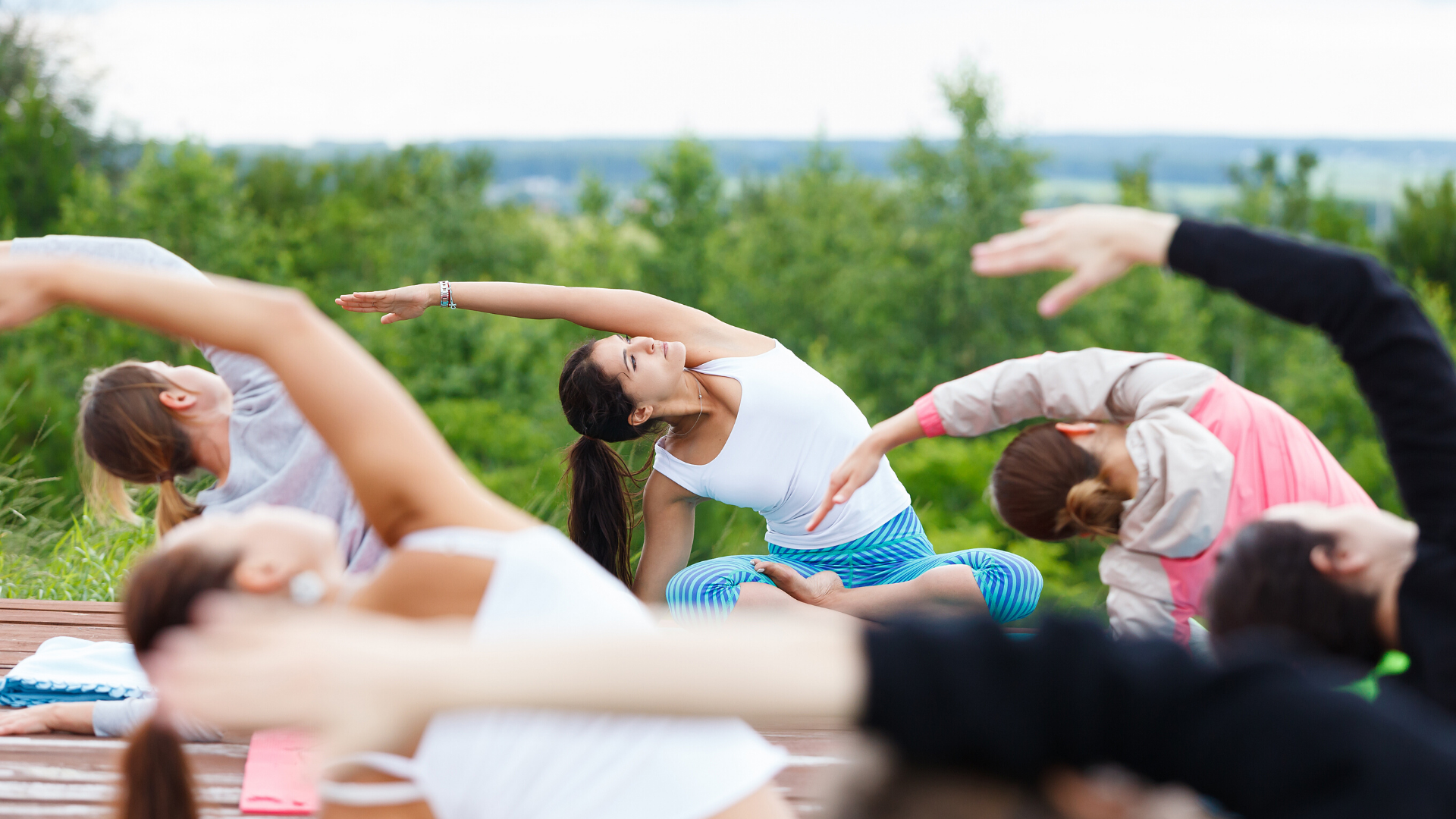 Group of yoga students practicing yoga outside