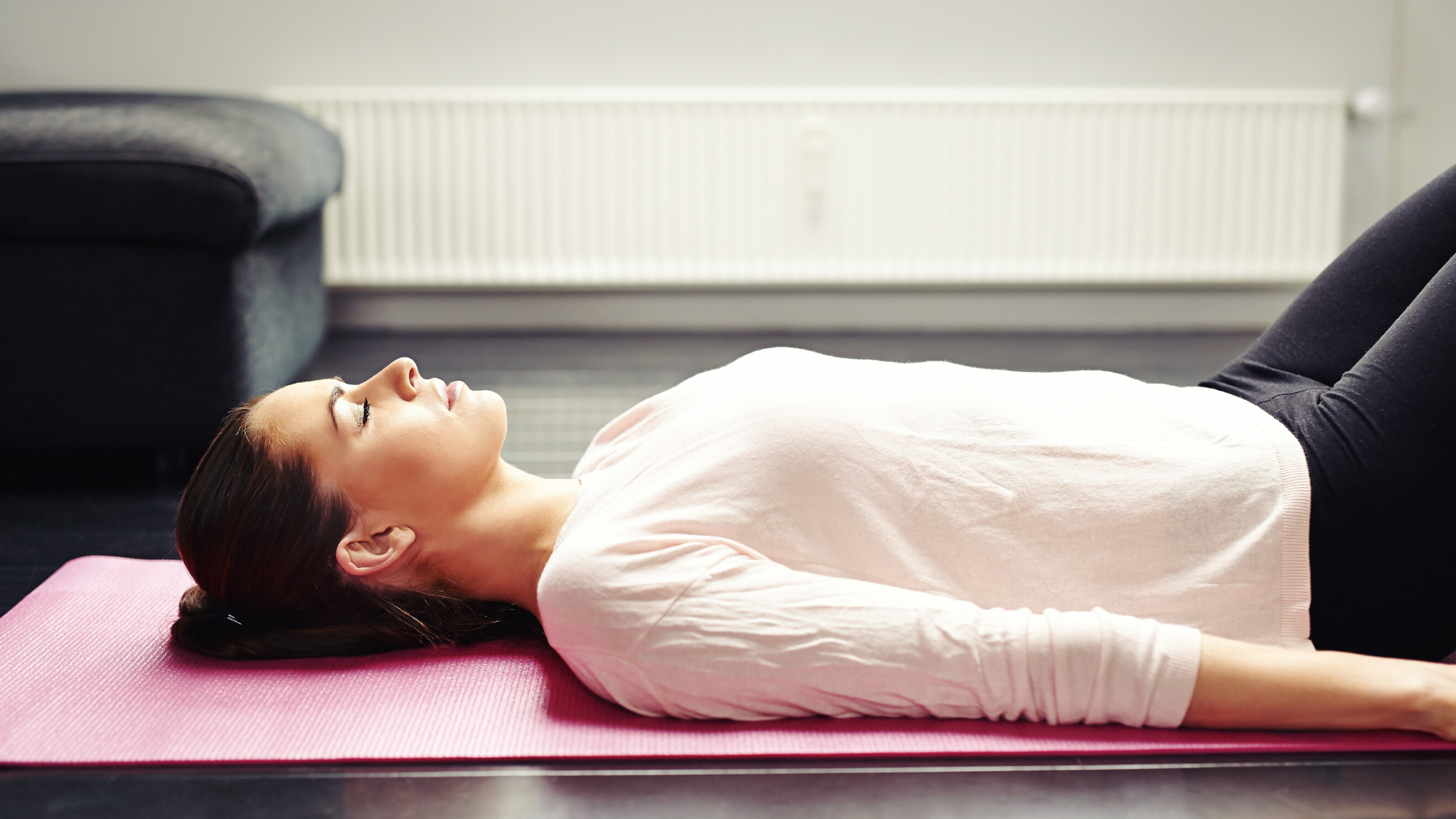 Woman practicing savasana yoga nidra yogic sleep.