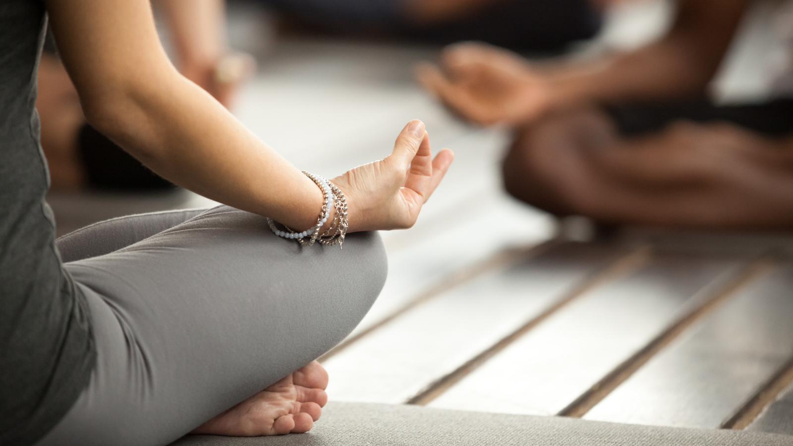 Young sporty woman practicing yoga lesson sitting in Sukhasana exercise, Easy Seat pose with Anjali Mudra gesture