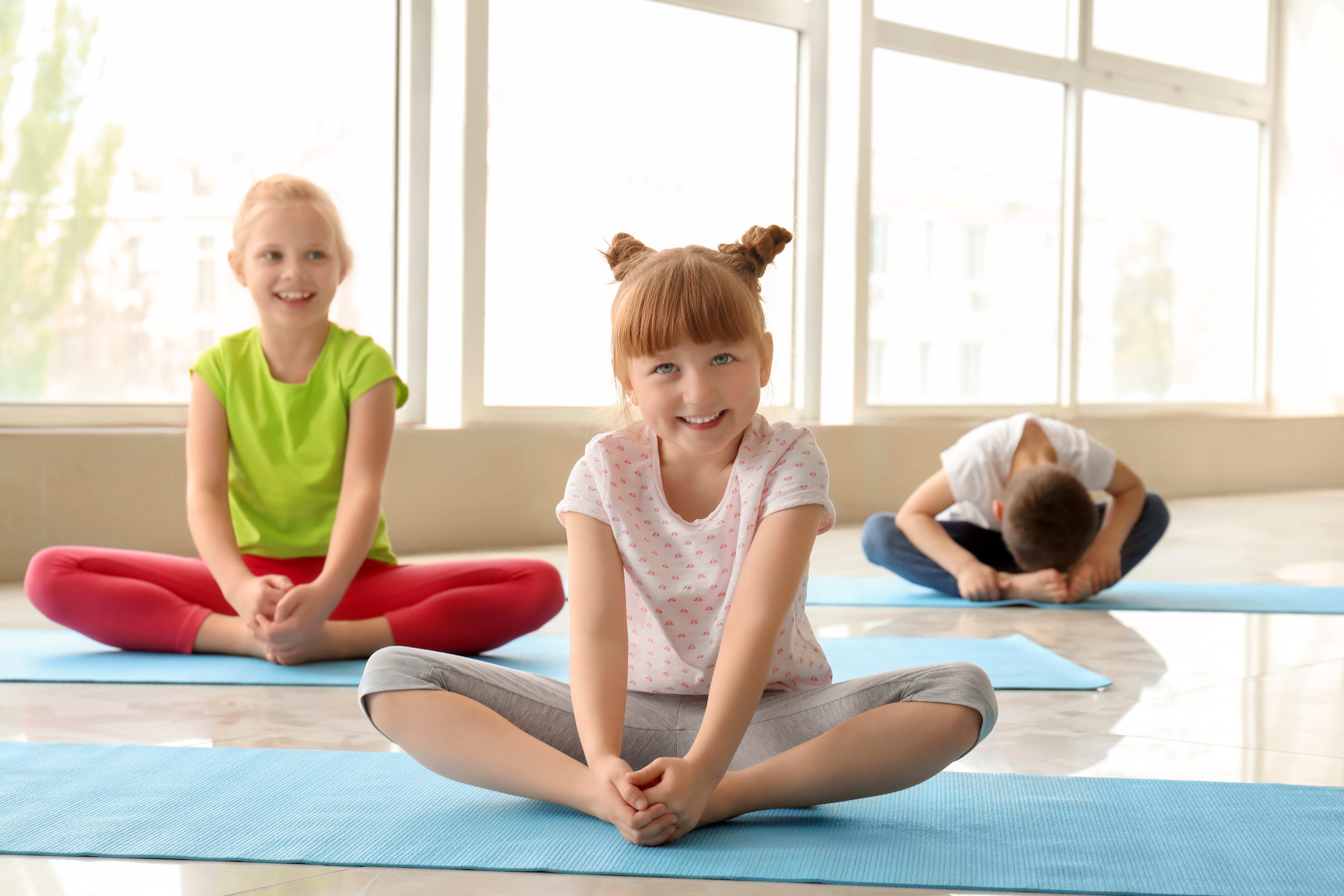 Children practicing yoga in Baddha Konasana (Bound Angle Pose)