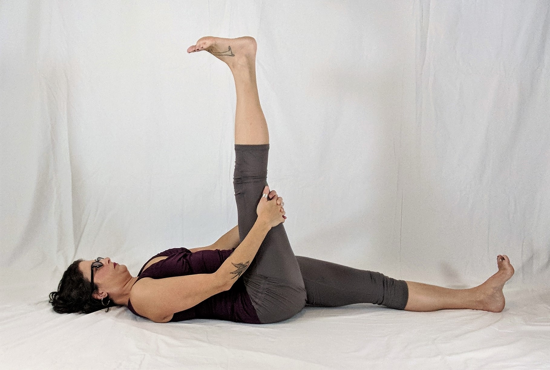 Reclining floor yoga pose with one leg raised