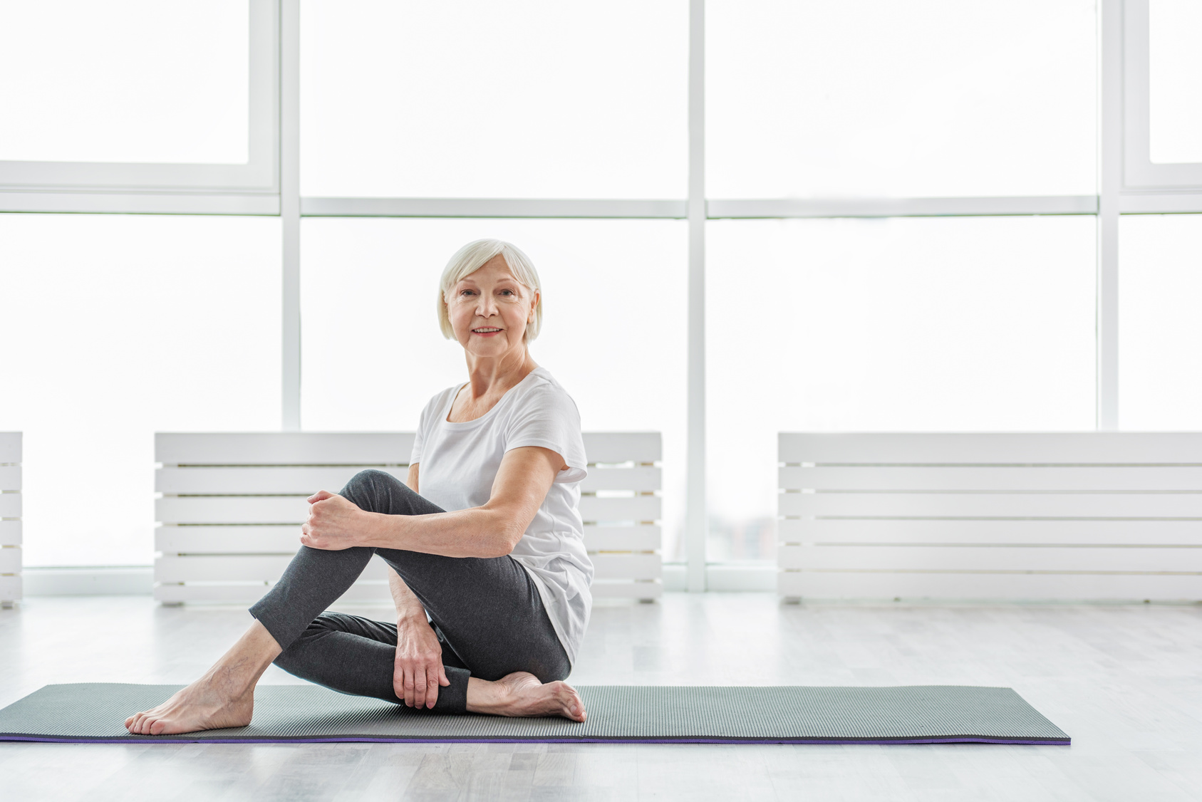 Older woman practicing yoga for health benefits recovering from stroke