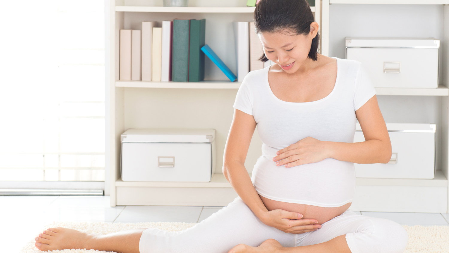 happy pregnant woman practicing prenatal yoga