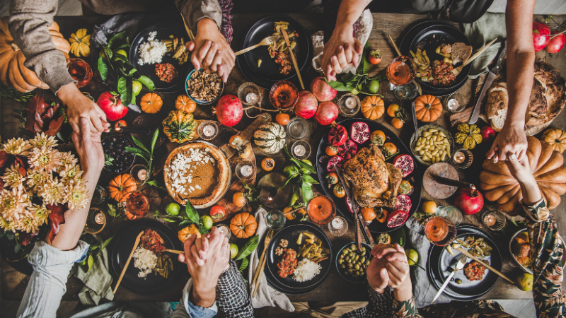 thanksgiving feast holding hands at the table