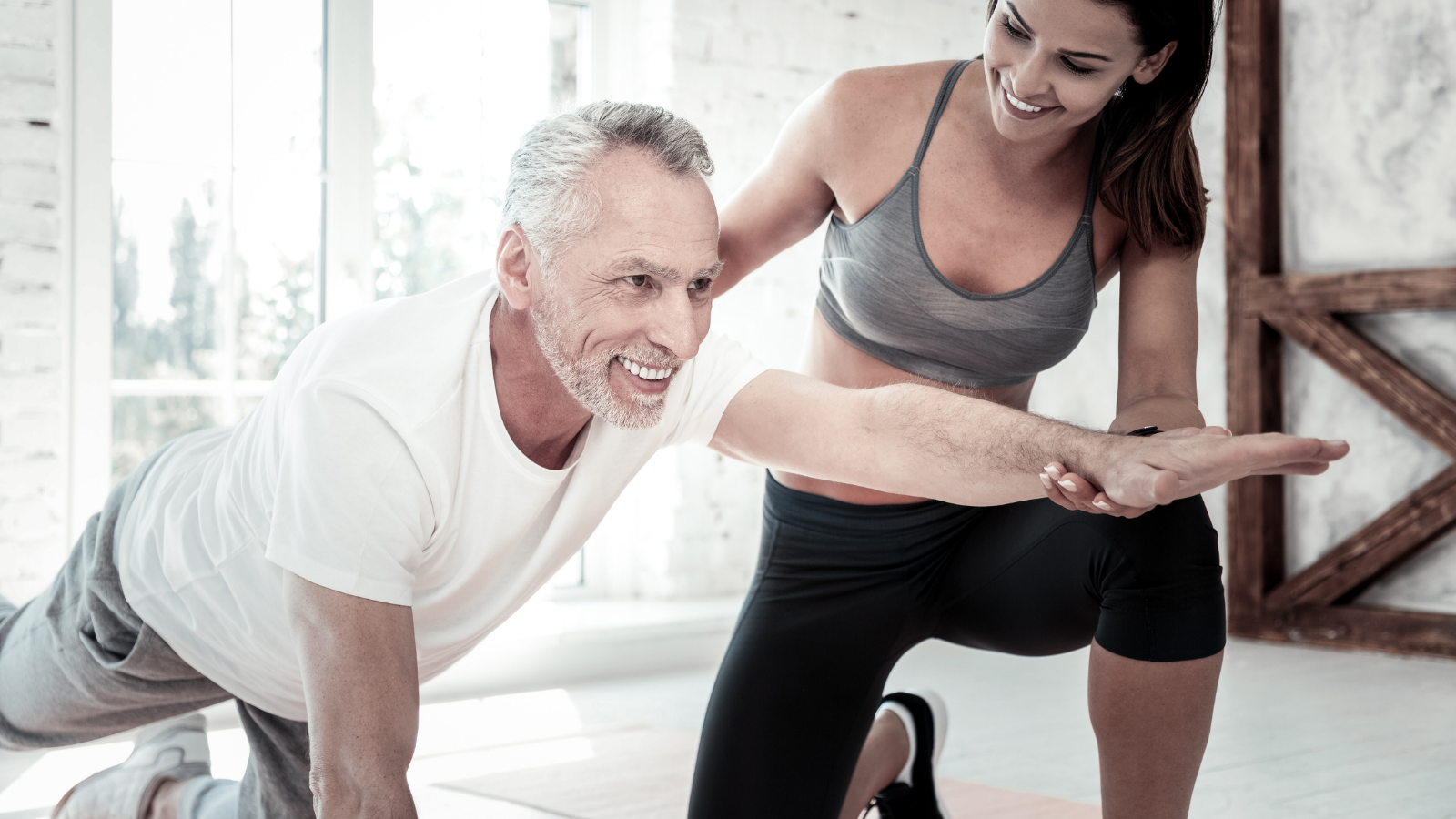 Senior man training with physiotherapist at home.