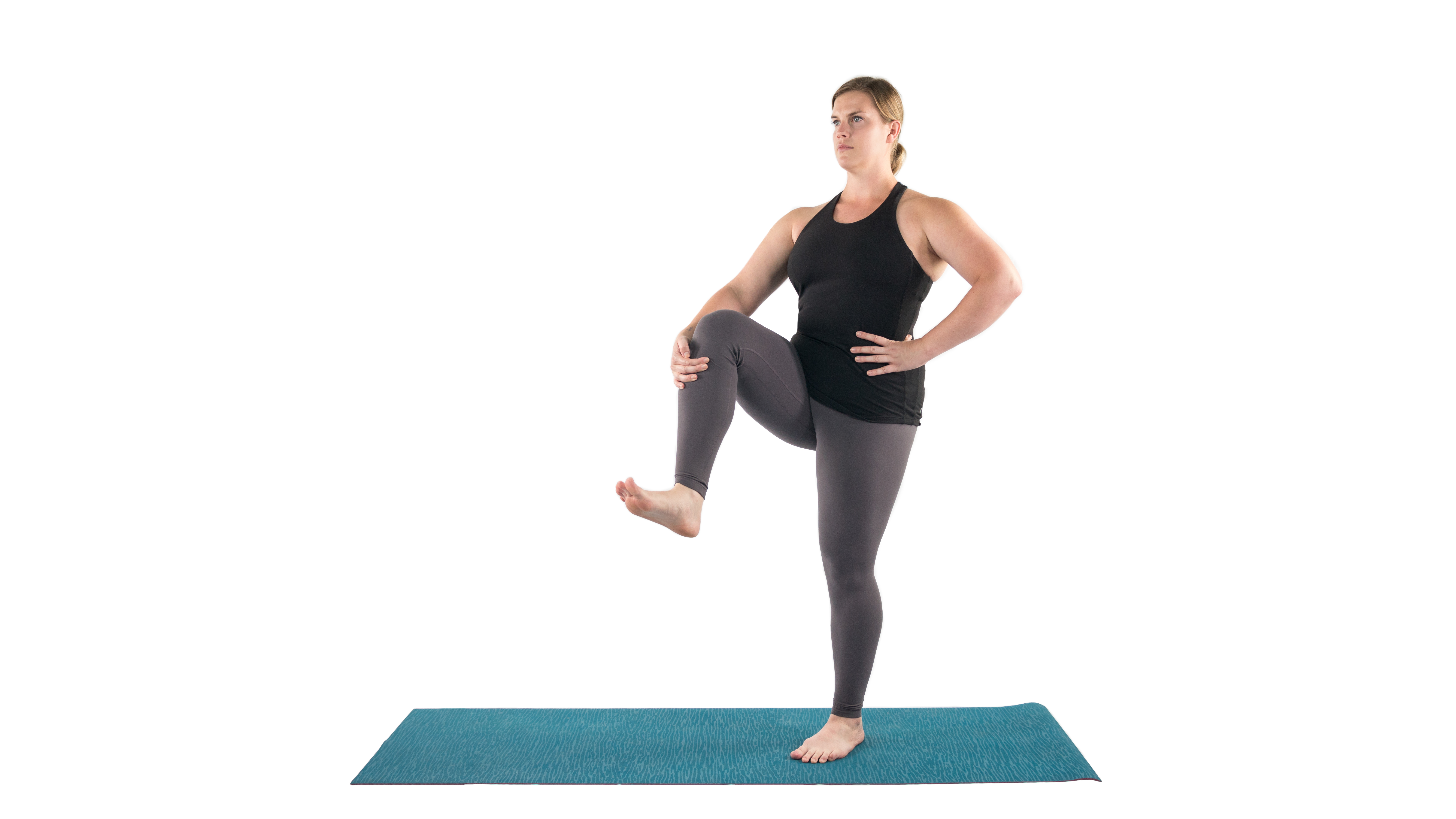 Woman in a simple standing balance yoga pose to stretch muscles in preparation for Dancer Pose