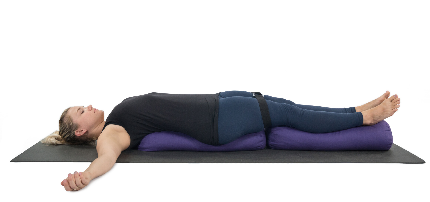 female yoga student practicing supported bridge pose setu bandha sarvangasana.