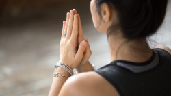 Namaste gesture close up photo, young attractive woman practicing yoga, contemplation concept