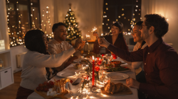 holidays and celebration concept - multiethnic group of friends are having Christmas dinner.