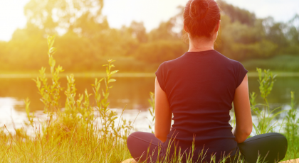 Young girl practices yoga on the shore of the River, concept of enjoying privacy, concentration