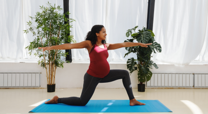 pregnant yoga student practicing kneeling warrior II pose