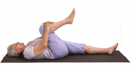 Older woman practicing yoga Apanasana