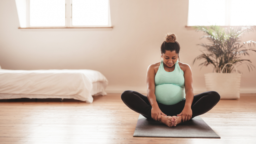 Practicing prenatal yoga designed for pregnant people in Bound Angle Pose (Baddha Konasana)