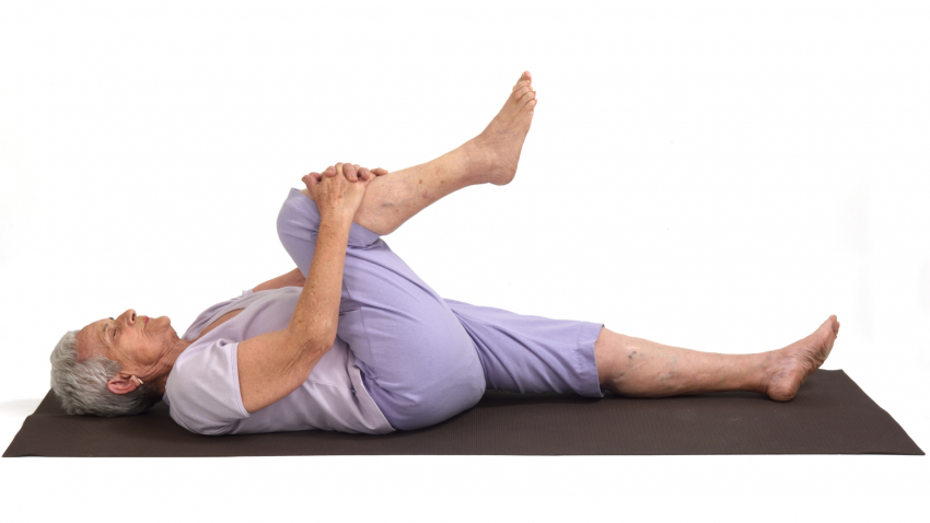 Older woman practicing yoga Apanasana