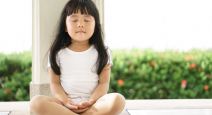 Young child practicing yoga meditation
