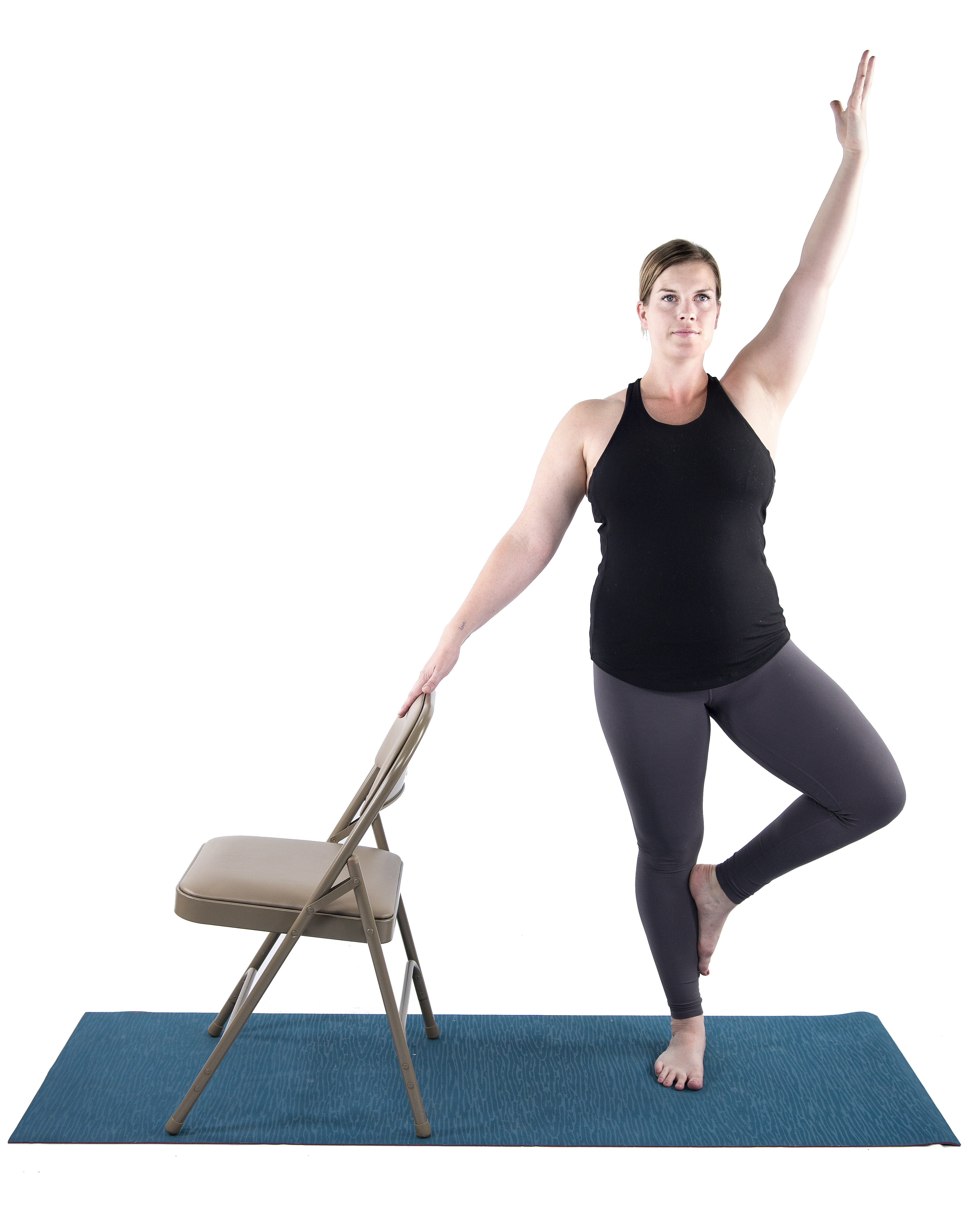 woman practicing balancing yoga pose, tree pose, vriksasana, with chair modification for Mulitiple Sclerosis