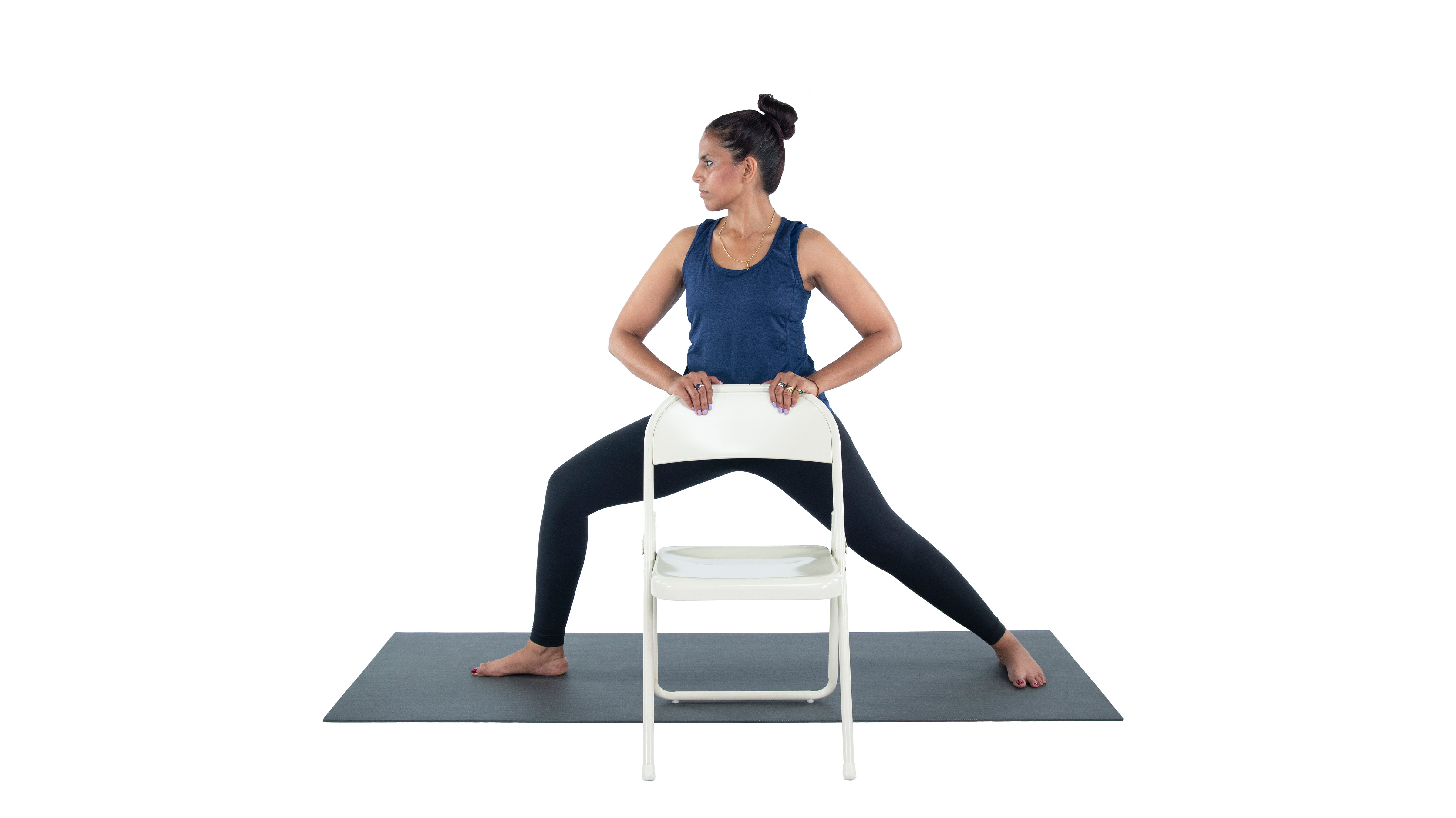 Woman with MS practicing warrior 2 yoga pose (virabhadrasana II) with chair assist for balance 